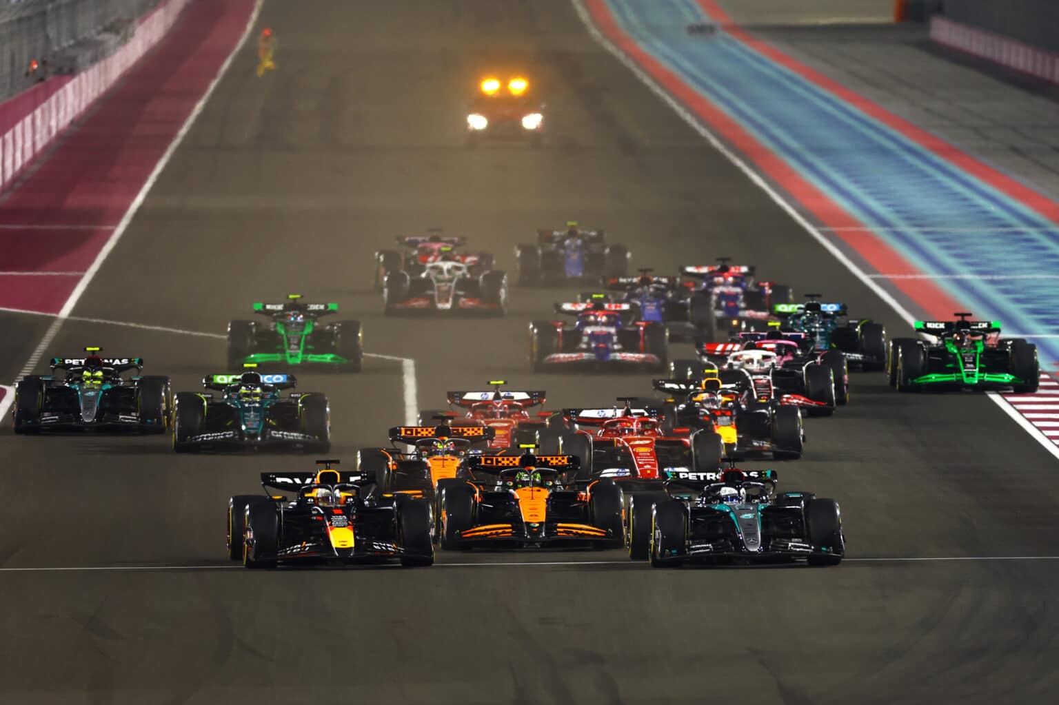 LUSAIL CITY, QATAR - DECEMBER 01: George Russell of Great Britain driving the (63) Mercedes AMG Petronas F1 Team W15 and Max Verstappen of the Netherlands driving the (1) Oracle Red Bull Racing RB20 lead the field into turn 1 at the start during the F1 Grand Prix of Qatar at Lusail International Circuit on December 01, 2024 in Lusail City, Qatar. (Photo by Mark Thompson/Getty Images) // Getty Images / Red Bull Content Pool // SI202412010398 // Usage for editorial use only //